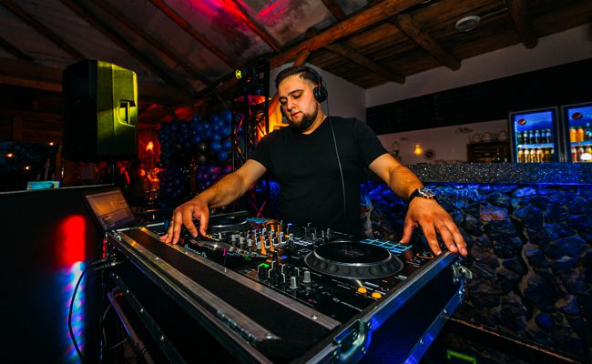 DJ miksujący muzykę na profesjonalnym mikserze dźwięku w klubie