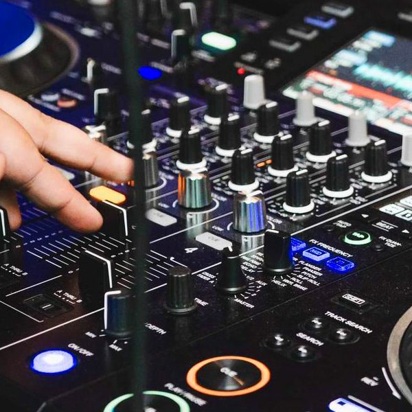 profesjonalny mikser dźwięku obsługiwany przez DJ-a, przygotowujący muzykę dla gości